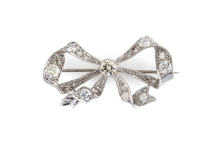 A stunning Art Deco platinum bow brooch set with diamonds, circa 1920s, stamped "18 PLAT.", 4.5cm wide, 8 grams total