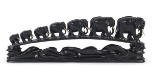 An Anglo-Indian large elephant bridge, carved ebony and bone with glass eyes, circa 1900, 62cm long