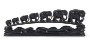 An Anglo-Indian large elephant bridge, carved ebony and bone with glass eyes, circa 1900, ​62cm long