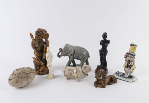 Chinese carved wooden statue of hares, Indian carved wooden statue of a woman, ceramic bull, lion, elephant and egg ornament as well as a ceramic clown statue, 20th century, (8 items), the largest 25cm high