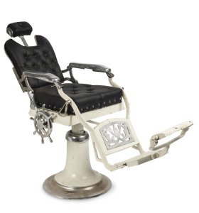 A barber's chair, cast iron, enamel and chrome with black leather seat and nautical style ship's wheel lever, early 20th century, with fold out foot plate and original headrest, ​54cm across the arms