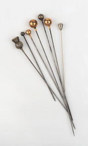 Seven assorted antique hatpins, rose gold and sterling silver, 19th and early 20th century, the largest 15cm long