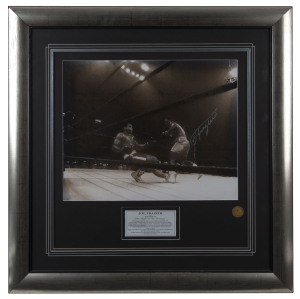 JOE FRAZIER vs MUHAMMAD ALI: action photograph of Ali falling into the ropes after being caught by Frazier's famed left hook during the 11th round of "The Fight of The Century" held at Madison Square Garden, March 8, 1971, SIGNED BY FRAZIER with a silver marker; Superstars & Legends CofA; framed & glazed, overall 81 x 80cm.