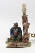 An Australian pottery lamp base with seated figure, mid 20th century, signed (illegible) and dated 1954, ​33cm high