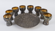 ERNST FRIES Australian pewter drink set comprising eight goblets and a platter, circa 1970, (9 items), stamped "E. Fries, Aust.", the platter 24cm diameter