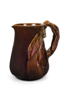 REMUED pottery jug with applied gumnuts and leave with branch handle, early shape with incised decoration, glazed in brown and pink, incised "Remued", 20cm high