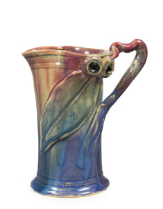 REMUED early pottery jug with applied gum nuts, branch handle and leaf, glazed in pink, blue and green, incised "Remued, Hand Made", 17cm high