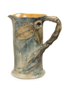 REMUED pottery jug with windswept branch handle, unusual applied leaves and gum nut, early blue glaze decoration with caramel interior, incised "Remued, 1933", 18cm high