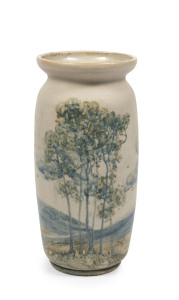 MERRIC BOYD tall pottery vase decorated with Australian landscape, an exceptional example of Boyd's workmanship, painted in the round with evocative landscape including clusters of gumtrees, mountain ranges and brooding storm clouds. One of the earliest and finest examples seen in our rooms. Incised "Merric Boyd, 1916", 25cm high, 11.5cm diameter