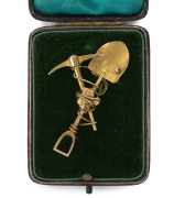 An Australian goldminer's brooch, crossed pick and shovel with gold nugget specimen and entwined rope, 19th century, ​5.75cm wide, 6.6 grams