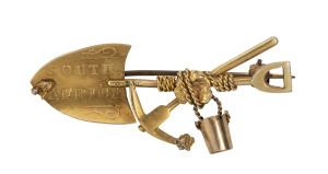 A goldminer's brooch, crossed pick and shovel with nugget specimen, rope and bucket, stamped "South Africa, 9ct", 4.5cm, 3.5 grams