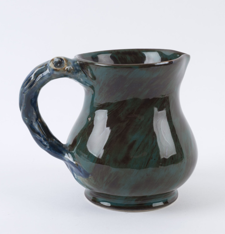 CRUFFEL Art Porcelain jug with branch handle glazed in green, brown and blue, 13.5cm high, 16cm wide