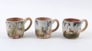 ARTHUR MERRIC BOYD & NEIL DOUGLAS: Three pottery mugs painted with kangaroos in landscape, ​all with blue backgrounds and reddish interiors, incised "A.M.B.", the largest 9.5cm high, 13cm wide