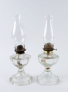 A pair of pressed glass oil lamps with embossed Greek key motif, early 20th century, ​the larger 44cm high overall