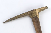 A miner's pick, four pound solid cast brass with later timber handle, ​81cm high - 2