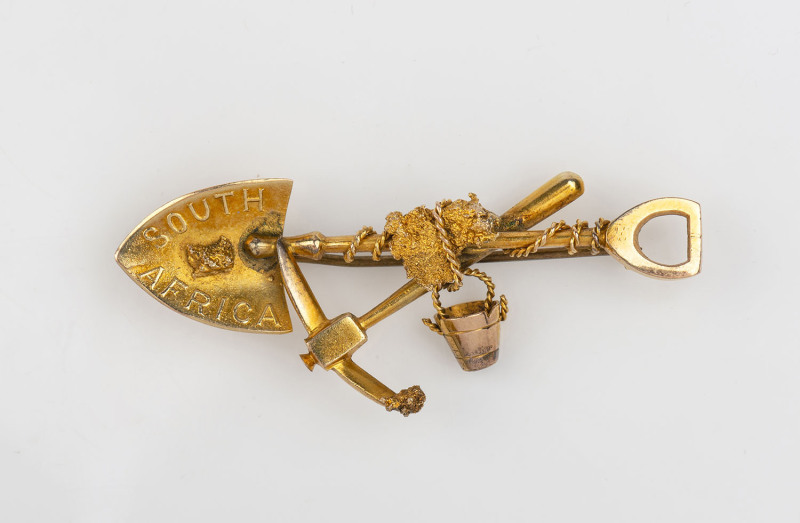 A goldminer's brooch, crossed pick and shovel with bucket, rope and gold nugget specimen, stamped "South African, 9ct" and engraved on reverse "EDITH", ​5cm long, 4.6 grams