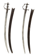 A pair of Indian Talwar swords in original leather scabbards, 91cm long