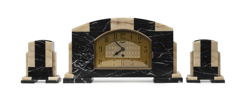 An Art Deco three piece clock set, black marble and onyx case with garnitures, circa 1930, ​the clock 25cm high, 45cm wide