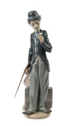 LLADRO "Charlie Chaplin, The Tramp" porcelain statue, 20th century, with original walking cane, blue factory mark to base, ​28.5cm high