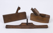 Three antique wood planes comprising a JOHN GREEN moulding plane, circa 1800, a router plane and a coffin plane, 19th century, the router plane 39cm wide