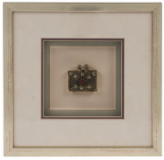 A Tibetan pendant, 19th century, framed and mounted, the pendant 5 x 5cm, frame 26 x 26cm overall