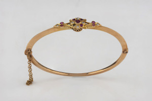 An antique 15ct rose gold bangle set with diamonds and rubies, 19th century, ​(missing one stone) 6.5cm wide, 6.3 grams total