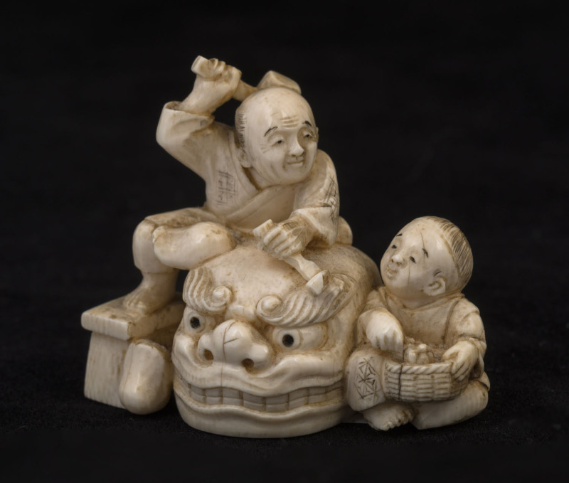 A Japanese carved ivory Okimono of the carvers, Meiji period, red seal mark to base, ​5cm high, 6cm wide