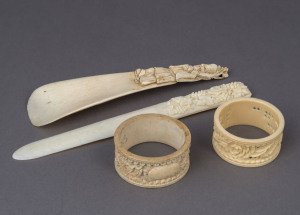 A Chinese carved ivory shoehorn, paper knife and two napkin rings, 19th and early 20th century, (4 items), the largest 15.5cm high