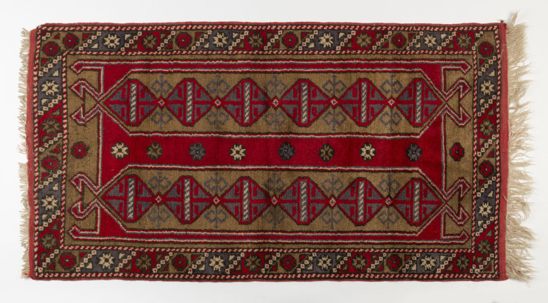 A hand-knotted red patterned tribal rug, mid 20th century, ​160 x 85cm