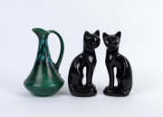 A pair of vintage porcelain cat statues together with a green ceramic jug, mid 20th century, ​the cats 21cm high