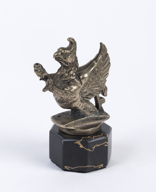 A griffin car mascot, silvered cast metal on later black marble base, circa 1930, ​12cm high overall