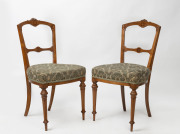 A pair of antique English carved walnut armchairs with brocade upholstery, circa 1875