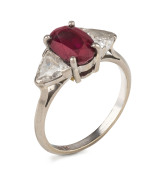 An 18ct white gold ring set with a stunning Burmese ruby flanked by two large kite cut white diamonds, purchesd from Hardy Brothers in Melbourne, stamped "18ct", 3.7 grams