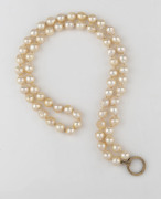 A strand of natural pearls with circular gold clasp, ​64cm long