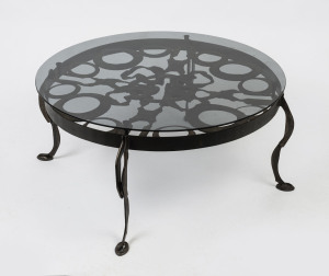 A circular coffee table, wrought iron and glass, circa 1970, signed "T. M.", 44cm high, 100cm diameter
