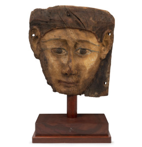 An ancient Egyptian mummy mask, carved and painted wood, most likely belonging to the inner sarcophagus, 26-27th Dynasty, circa 660-650 BC, 29cm high. With accompanying certificate of authenticity from B.C. Galleries, Armadale, Victoria
