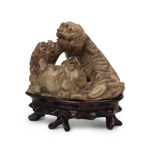 A Chinese carved soap stone lion figural group on carved wooden stand, 19th/20th century, 9cm high overall