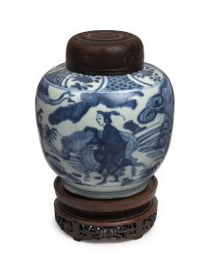 A Chinese ovoid porcelain jar, underglaze blue decoration with figures and donkey in landscape, Ming Dynasty, circa 1500, with accompanying finely carved wooden stand and lid, ​23cm high overall
