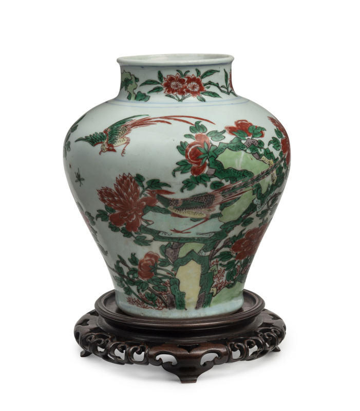 A Chinese Wucai transitional vase decorated with peonies and exotic birds, circa 1600, with a fine carved timber stand, 36cm high