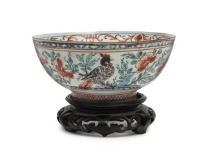 A Chinese porcelain bowl with Amsterdam Bont Dutch decoration of exotic birds and foliage, circa 1720, with accompanying carved wooden stand, 6.5cm high, 14.5cm diameter