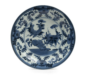 A Japanese Arita ware plate, decorated in underglaze blue with stylized flowers and border of Karakusa flowers, 18th century, exhibited at the Japanese Aesthetic Exhibition in 2007 with associated label, 21cm diameter