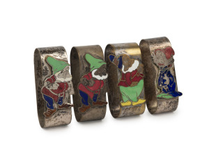 SNOW WHITE AND SEVEN DWARFS: rare plated brass napkin rings (4) with enamelled "dwarf" decorations, comprising "Doc" (2), "Happy" and "Dopey"; late 1930s, length of each 6cm. (4).