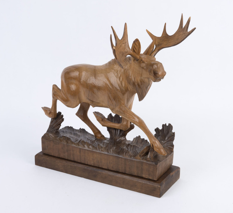 A carved wooden statue of a moose, circa 1960s, ​33cm high, 38cm long