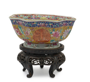 A Chinese eight sided bowl with enamel decoration on finely carved wooden stand, Guangxu period, 19th century, the bowl 7cm high, 16cm wide