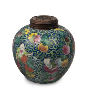 A Chinese porcelain jar with boys and fruit on blue ground with carved timber lid, Republic period, 21cm high, 20cm wide