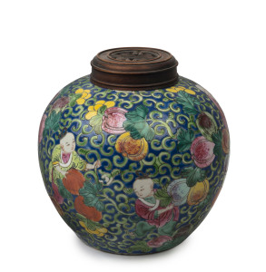 A Chinese porcelain jar with boys and fruit on blue ground with carved timber lid, Republic period, ​21cm high, 20cm wide