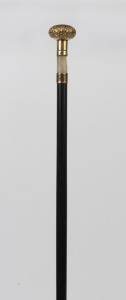An antique walking stick with gilt metal handle, mother of pearl collar, ebony shaft and brass ferrule, 19th century, 86cm high