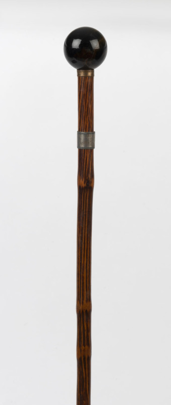 A walking stick with spherical tiger eye handle, silver and gold plated collars, cane shaft and metal ferrule, 19th century, ​83cm high