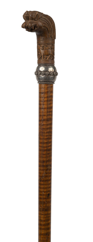 A walking stick with carved Indian timber sandalwood handle, silver collar, fiddleback shaft and brass ferrule, 19th century, ​90cm high