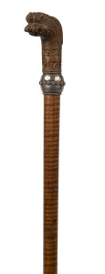 A walking stick with carved Indian timber sandalwood handle, silver collar, fiddleback shaft and brass ferrule, 19th century, 90cm high